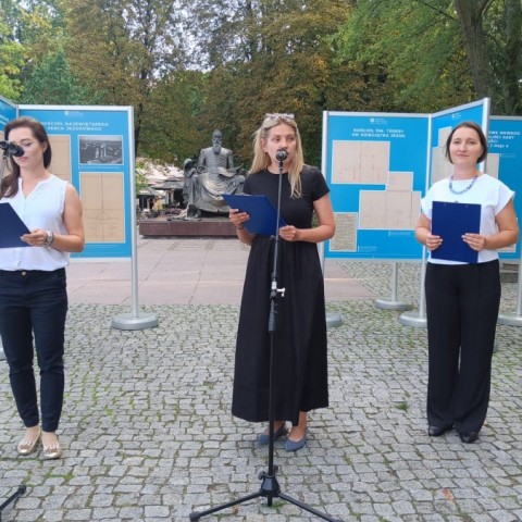 Powiększ obraz: Trzy kobiety na tle plansz wystawowych