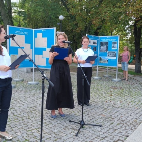 Powiększ obraz: Trzy kobiety na tle plansz wystawowych