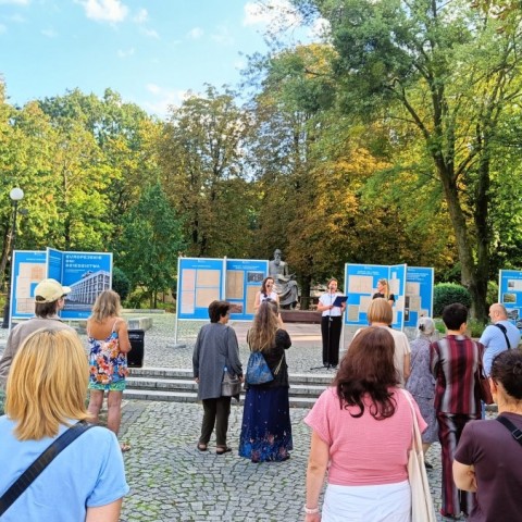 Powiększ obraz: grupa ludzi oglądająca wystawę