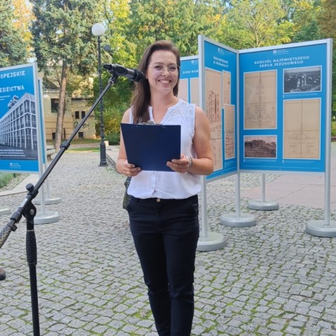 Powiększ obraz: kobieta na tle wystawy